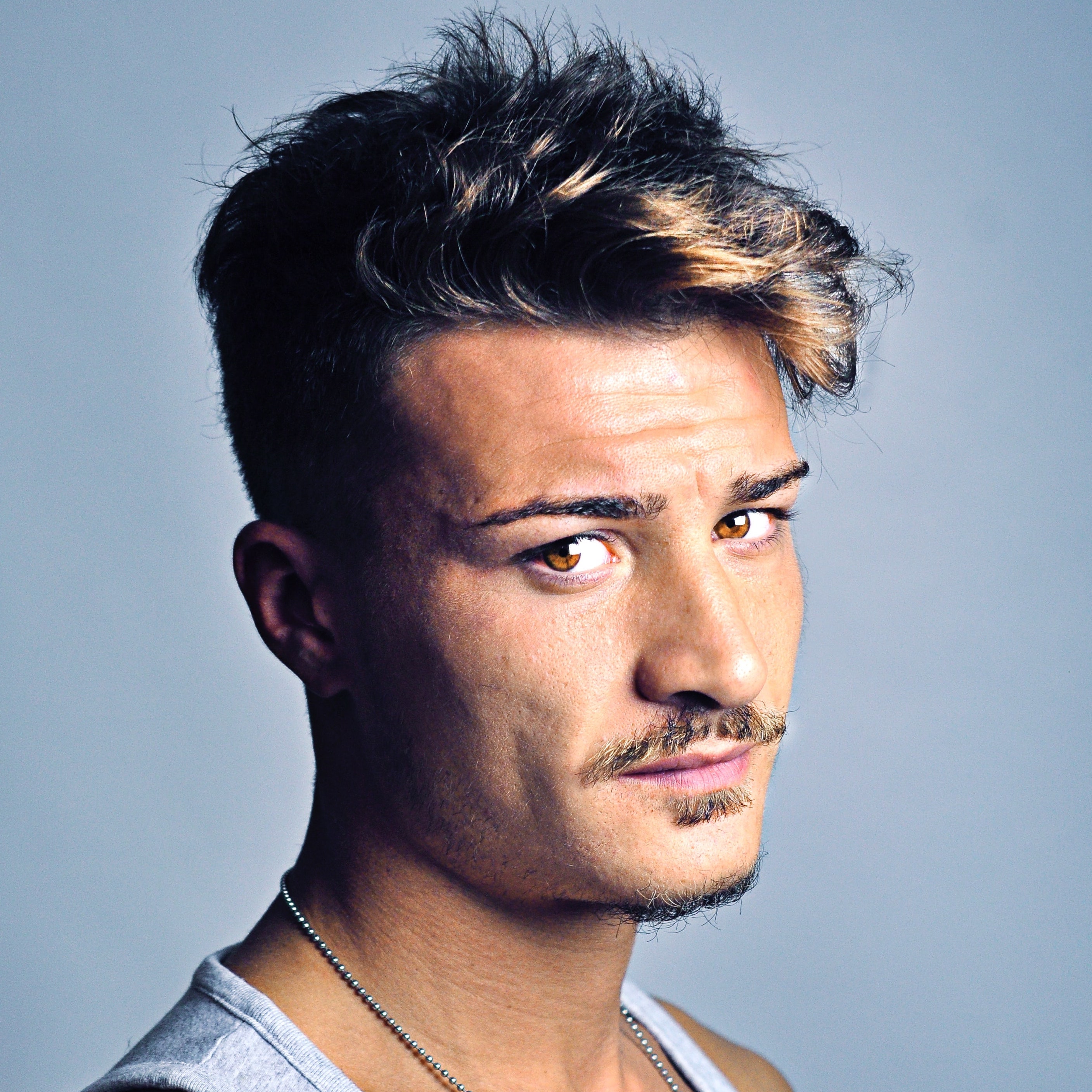 Man with short hair combed sideways with highlights